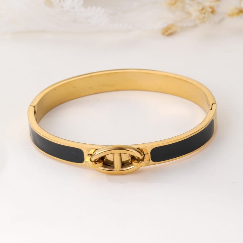 Gold-toned women h bangle bracelet with black enamel inlays and a central interlocking logo clasp minimalist fashion bracelet.