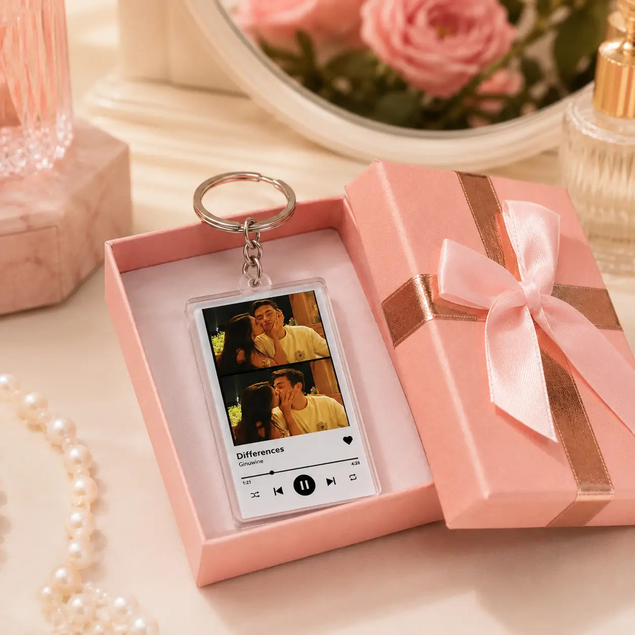 A rectangular transparent acrylic keychain featuring a personalized photo of two people kissing with the song title differences and a music player interface design.