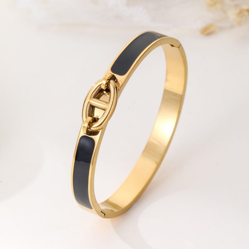 women h bangle gold enamel minimalist bracelet featuring a gold-tone bangle with black enamel inlay and a central interlocking link design as a fashion bracelet minimalist accessory.