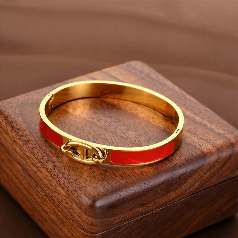Women h bangle gold enamel minimalist bracelet featuring a gold-tone bangle with a vibrant red enamel band and an interlocking h clasp as a fashion bracelet minimalist for women.
