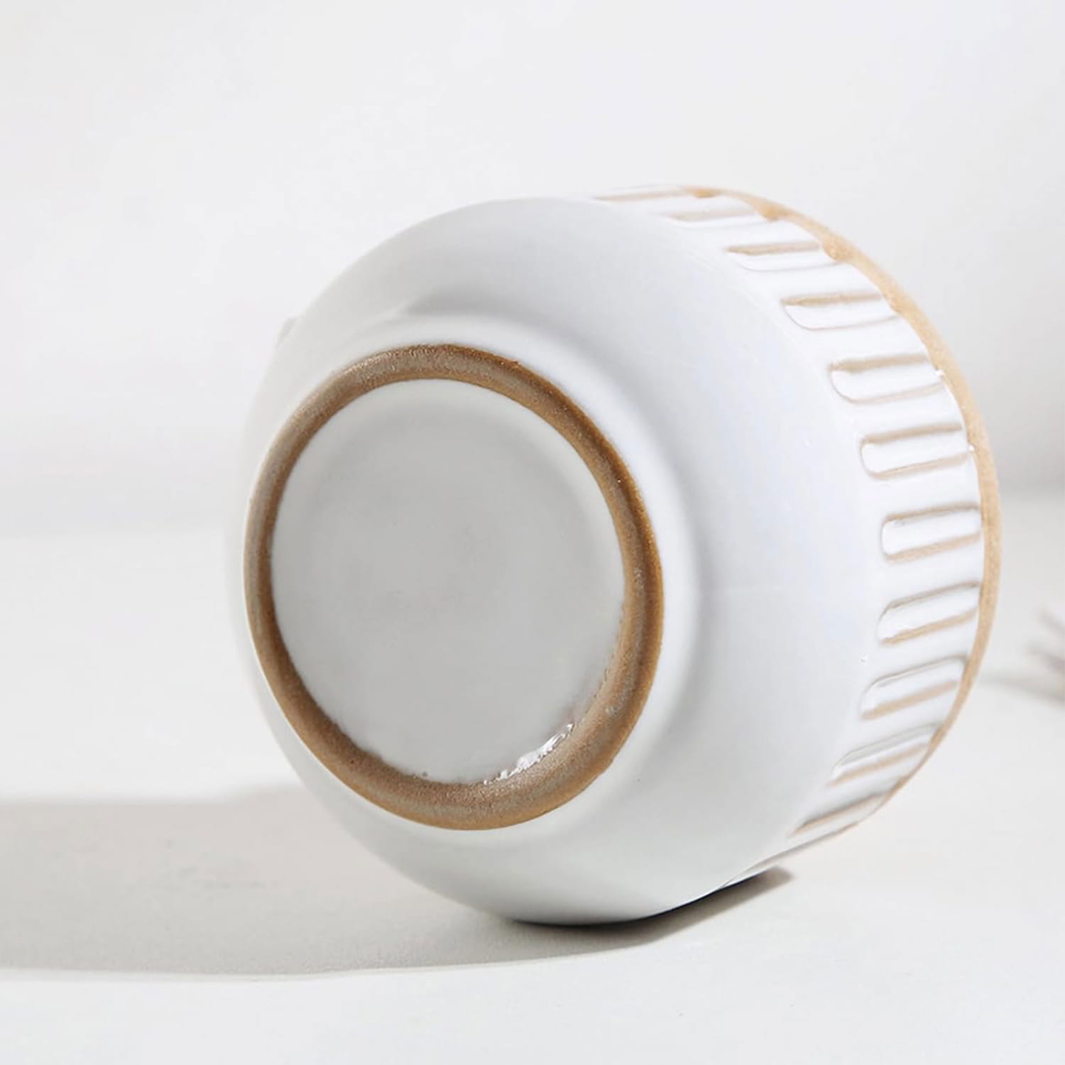 white ceramic flower vase with a textured ribbed exterior and natural toned glazed rim as boho tabletop decor