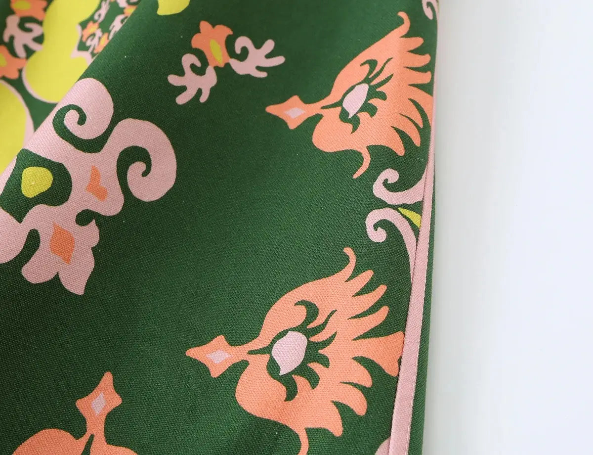 Grünes Seidentuch mit leuchtend pfirsichfarbenen, stilisierten Vögeln und pinkfarbenen floralen Motiven in einem floralen zweiteiligen Midi-Rock-Set im Boho-Outfit-Stil.