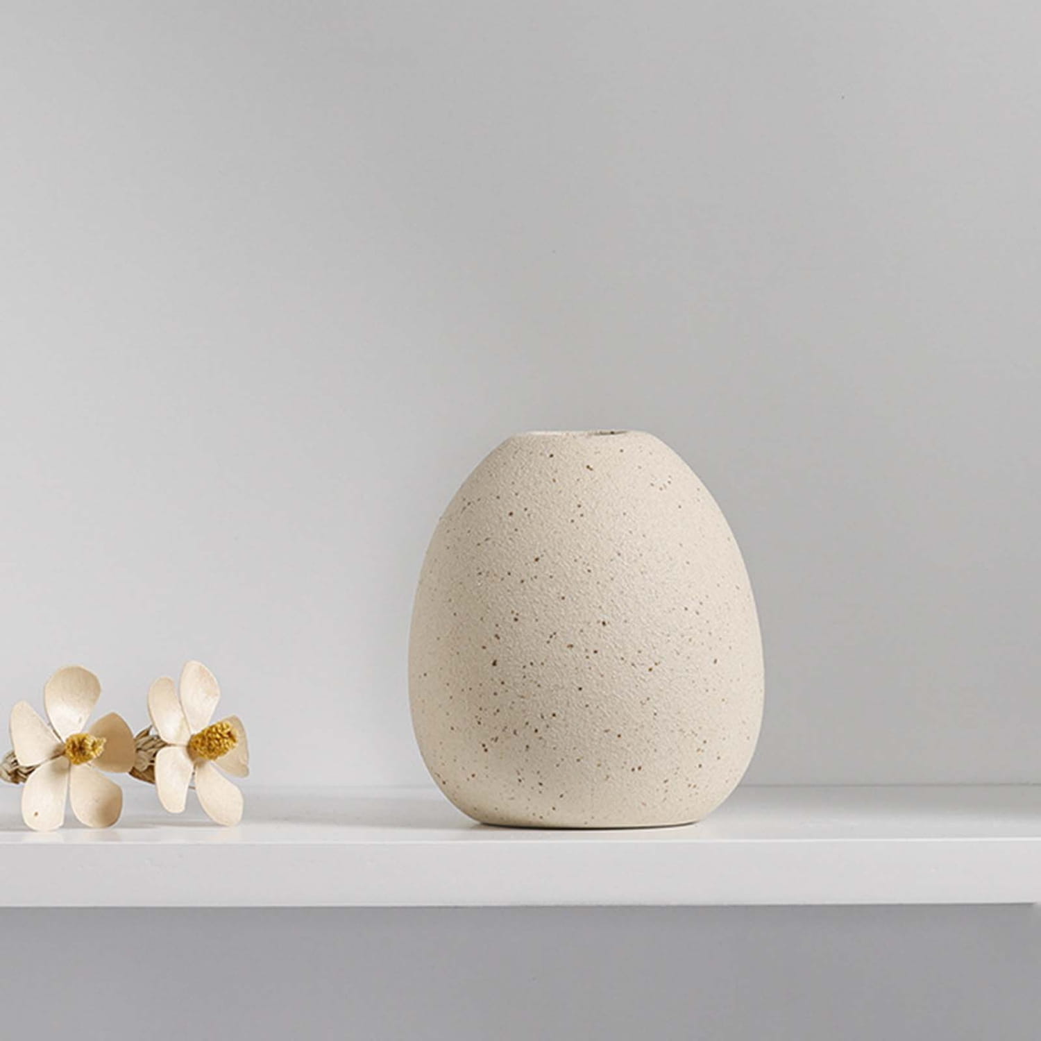 Cream-colored speckled ceramic flower vase with a smooth rounded egg-like shape ideal for boho tabletop decor.