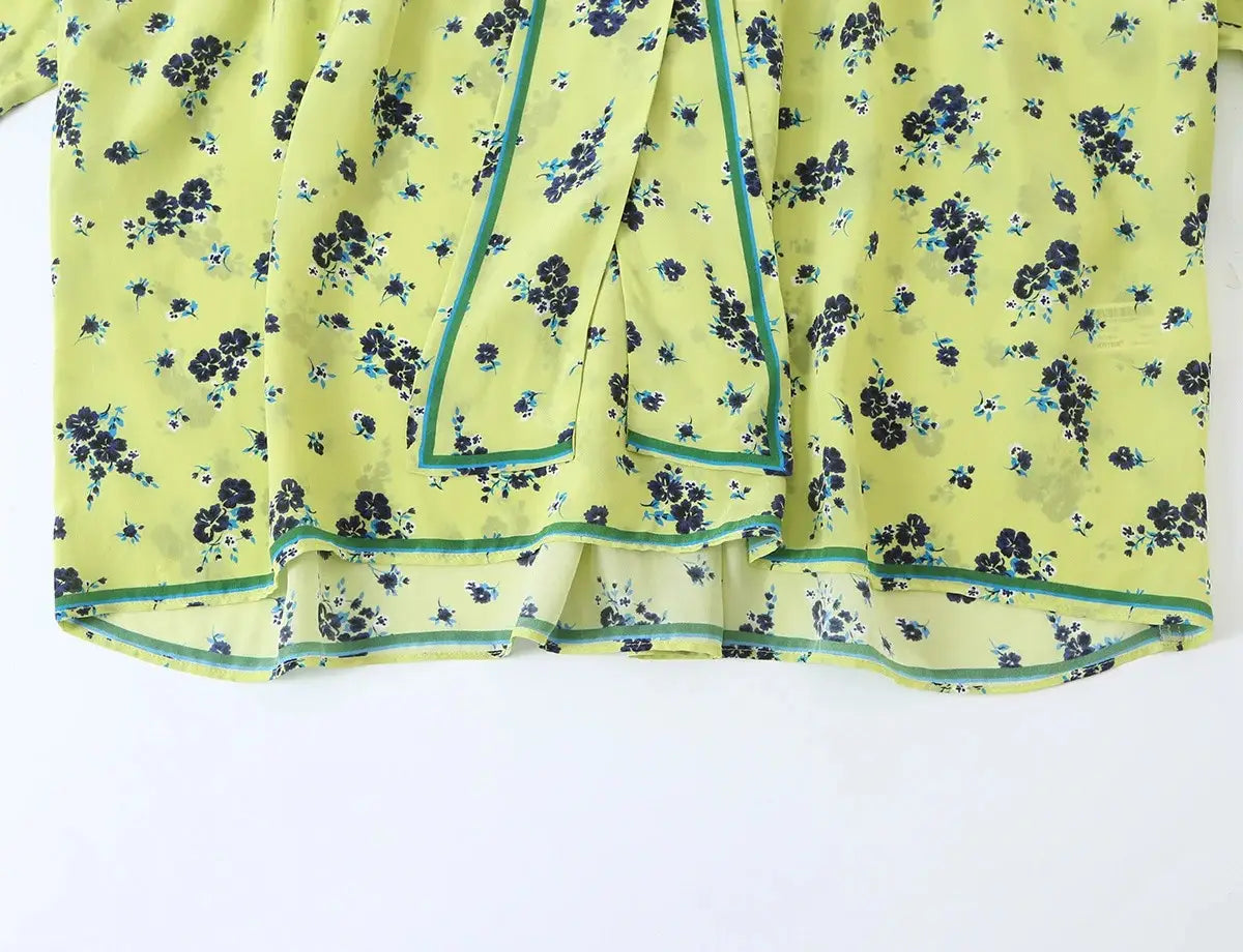 Ein hellgrünes Chiffon-Zweiteiler-Midi-Rock-Set im Boho-Outfit-Stil mit einem zarten schwarzen und türkisfarbenen Blumenmuster und passender Zierkante entlang des Saums sowie der Seitennähte.