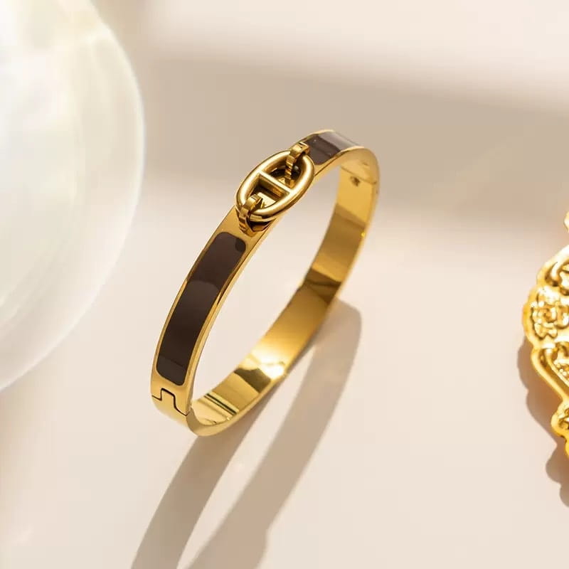 Women h bangle gold enamel minimalist bracelet featuring a gold-toned bangle with two horizontal black enamel stripes and an interlocking chain clasp as a sleek fashion bracelet minimalist design.