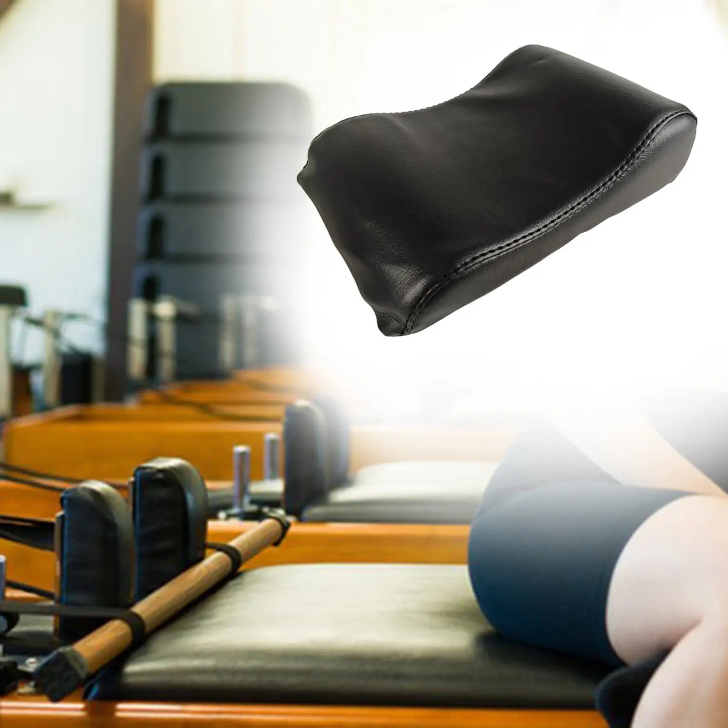 Black leather neck support pillow with stitched edges designed for Pilates reformer use.