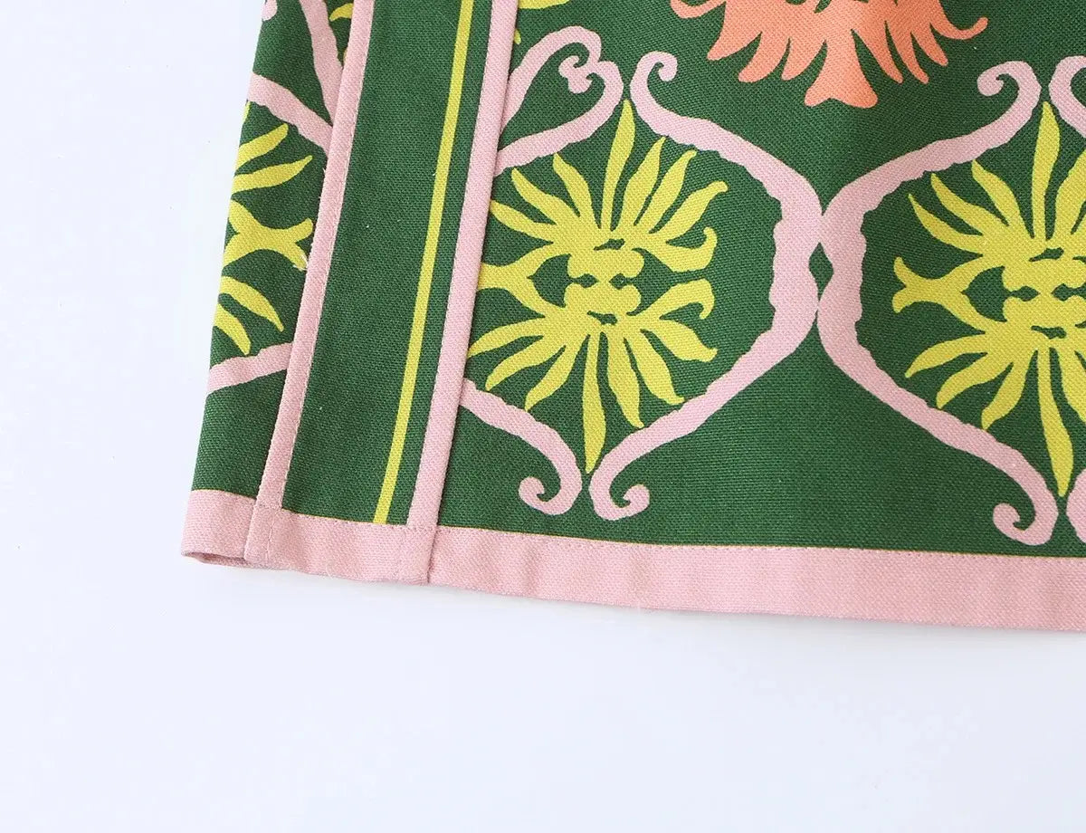 Grünes Stoff-Blumen-Zweiteiler-Midi-Rock-Set mit einem leuchtenden gelben und pinkfarbenen Blumenmuster sowie dekorativen, farblich passenden Bordüren für ein Boho-Outfit.