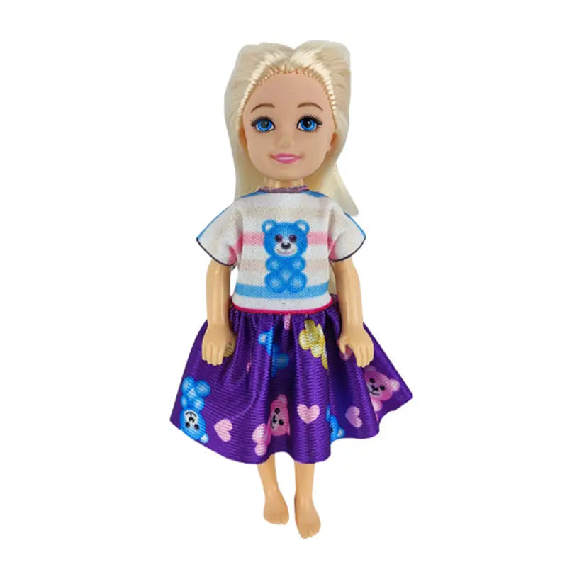 Eine Puppe mit blondem Haar, die ein Puppenkleidungs-Set mit 6-teiligen Modebekleidungszubehörteilen trägt, bestehend aus einem weißen kurzärmeligen Oberteil mit blauen Bären und pinken Streifen sowie einem violetten Rock mit bunten Bären und Herzen.