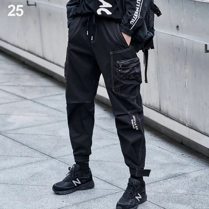 Herren schwarze taktische Cargo-Jogginghosen mit mehreren Taschen und Details mit weißen Nähten, ideal für Streetwear.