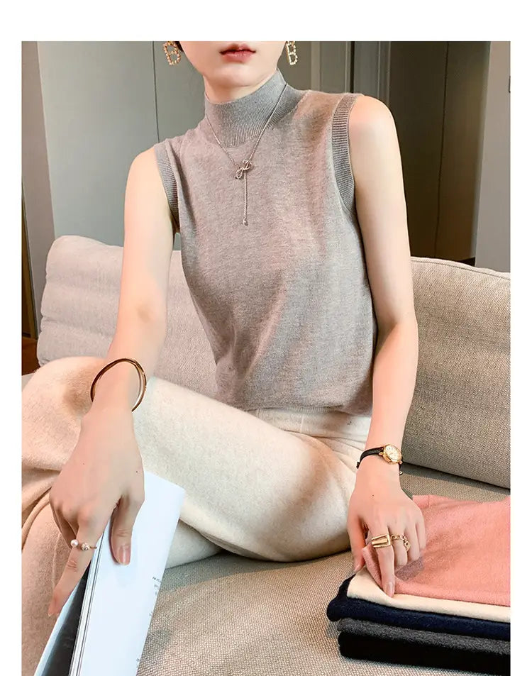 A soft heather gray wool turtleneck sleeveless sweater vest with a ribbed neckline and delicate knit texture.