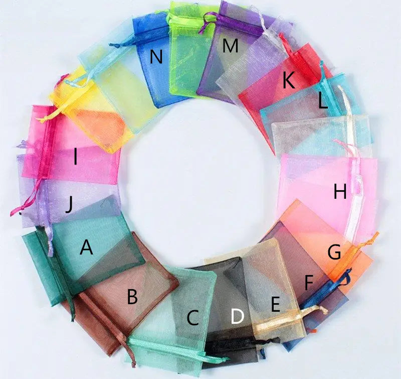 Une composition circulaire de sachets-cadeaux en organza translucide, disponibles en rose, bleu, vert, jaune et violet, pour des faveurs de mariage personnalisées en décapsuleur en forme de cœur.