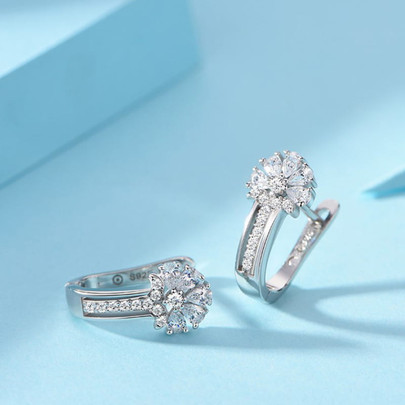 Sterling silver zircon flower hoop earrings featuring silver flower-shaped design with sparkling clear crystals set in a delicate pave style.