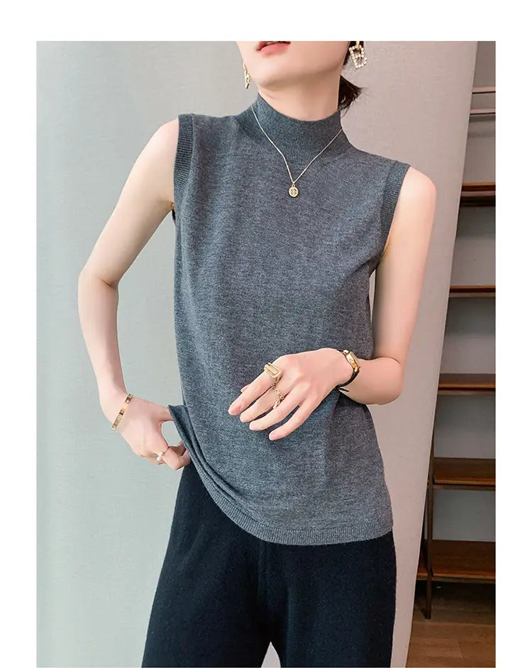 Gray wool turtleneck sleeveless sweater vest with soft textured knit fabric and ribbed hem.