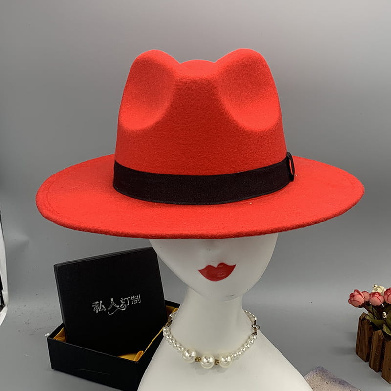 A vibrant red unisex woolen felt fedora hat with a black ribbon band and feather accent.