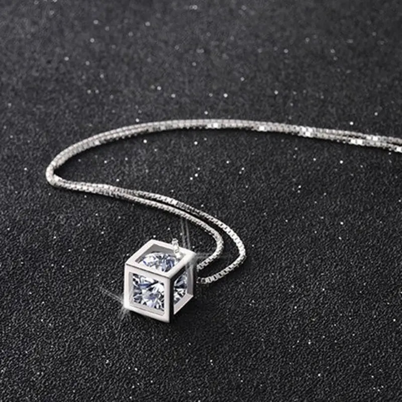 Collier de pendentif en zirconium carré argenté, présentant un pendentif en forme de cube en argent, orné de pierres en zirconium cubiques transparentes, dans un design moderne et épuré.