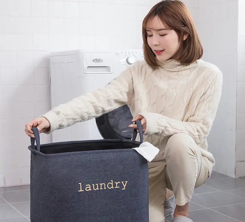 dark gray fabric foldable laundry basket with laundry embroidered in beige thread for organized storage baskets