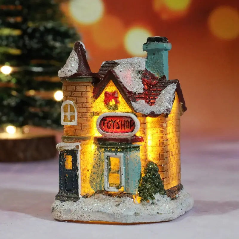 Une façade miniature en brique, type jouet de boutique, maison du village de Noël à LED, avec un toit blanchit par la neige, des lumières intérieures jaunes éclatantes et un panneau ovale rouge de boutique, veilleuse à batterie.