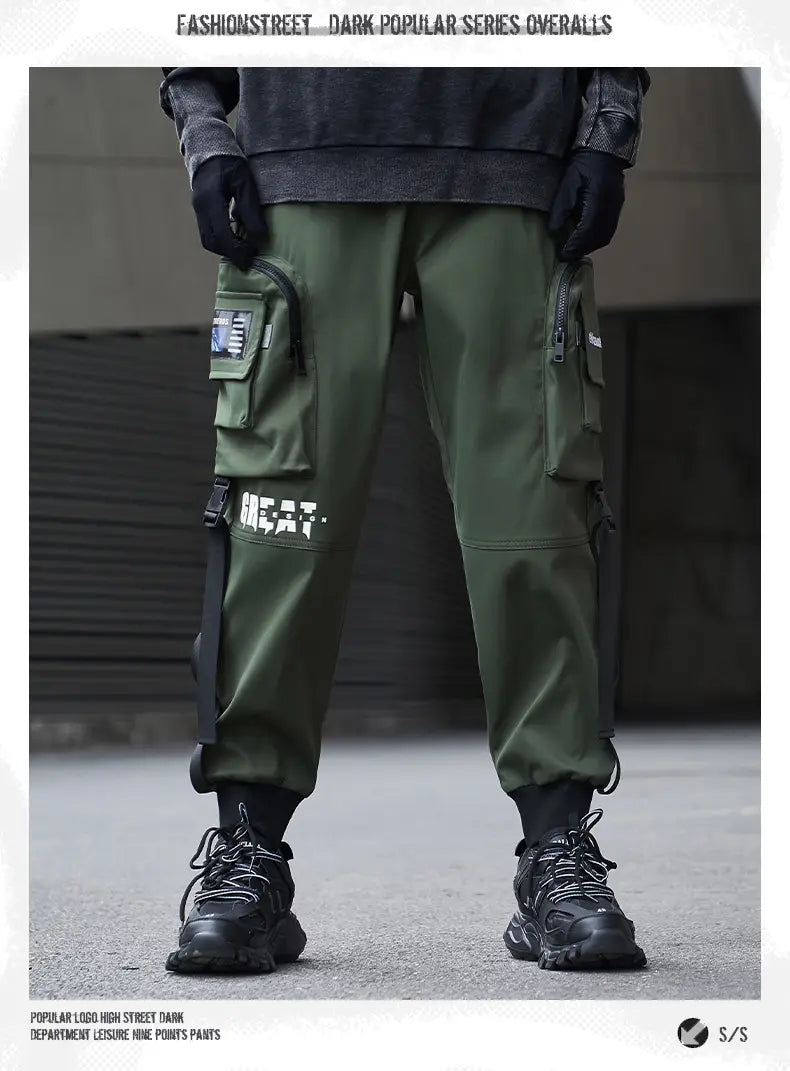 Herren schwarze taktische Cargo-Jogginghosen im Streetwear-Stil in dunkel Olivgrün mit mehreren Taschen und Great-Logo am Oberschenkel.