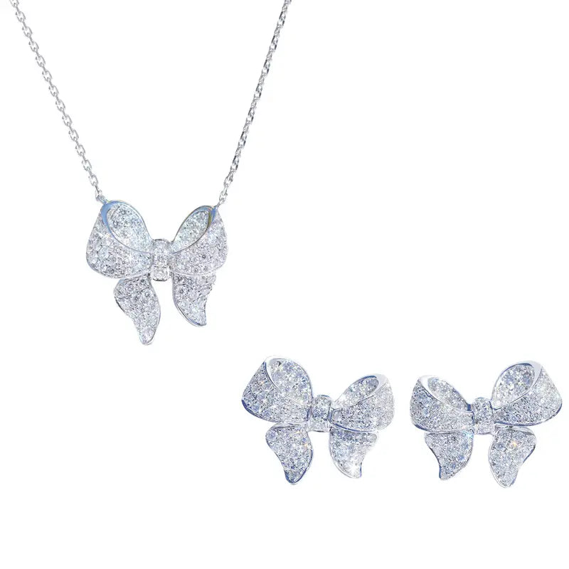A sparkling silver bowknot zircon necklace and earrings set adorned with numerous clear crystals.