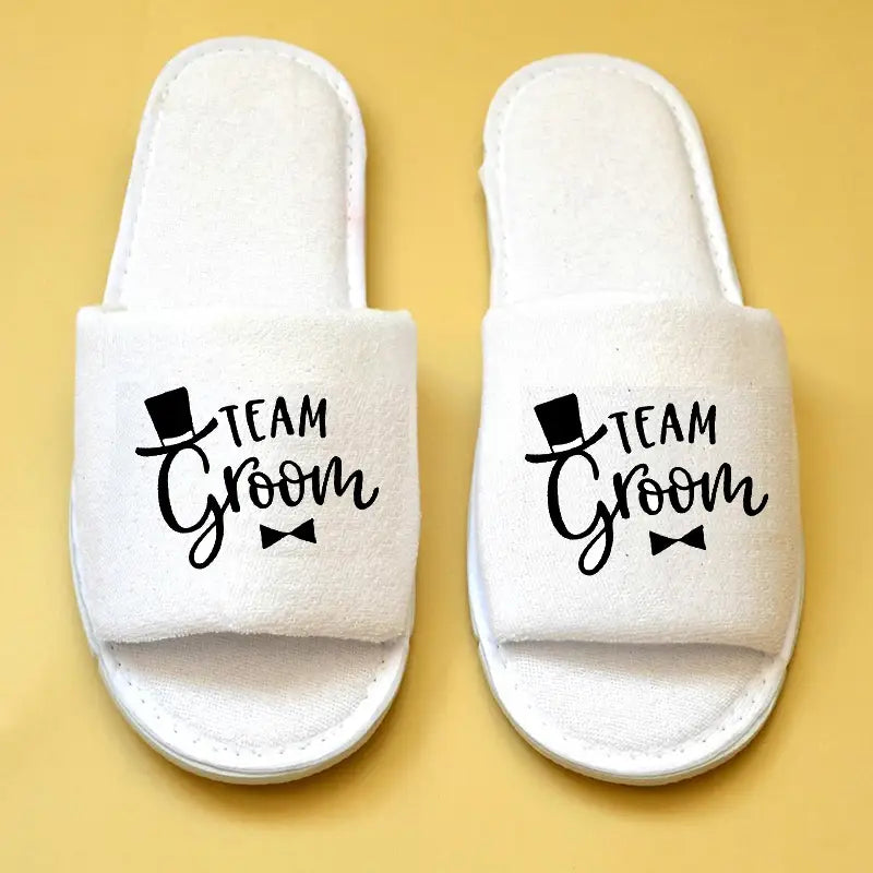 Weiße „Team Bräutigam“-Schlupf-Brautparty-Slipper mit einem schwarzen Zylinderhut- und Fliege-Design, geeignet für Hochzeits-Slipper.