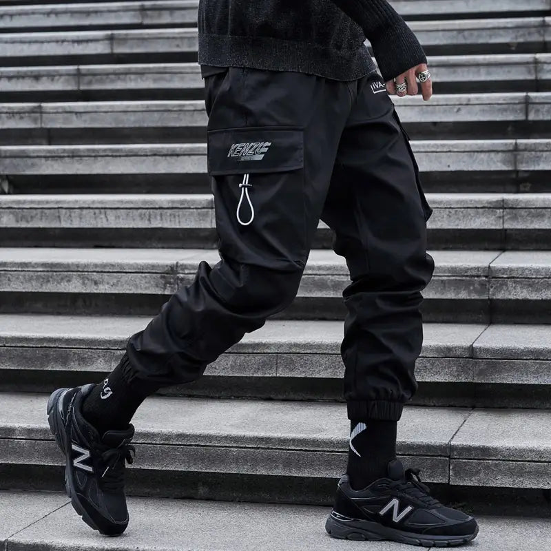 Herren schwarze taktische Cargo-Jogginghosen mit einem schlanken, funktionalen Design mit mehreren Taschen und dezentem weißem Branding am Oberschenkel – perfekt für Streetwear.