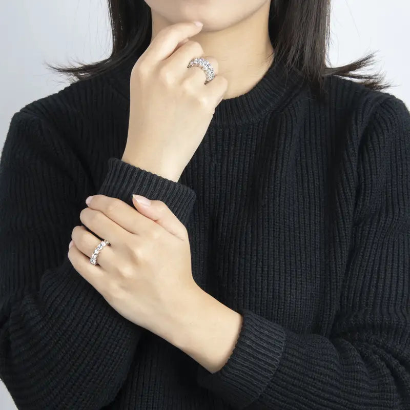 Une bague d’éternité cœur en argent sterling, avec une bande argentée étincelante ornée d’une rangée de pierres facettées transparentes.
