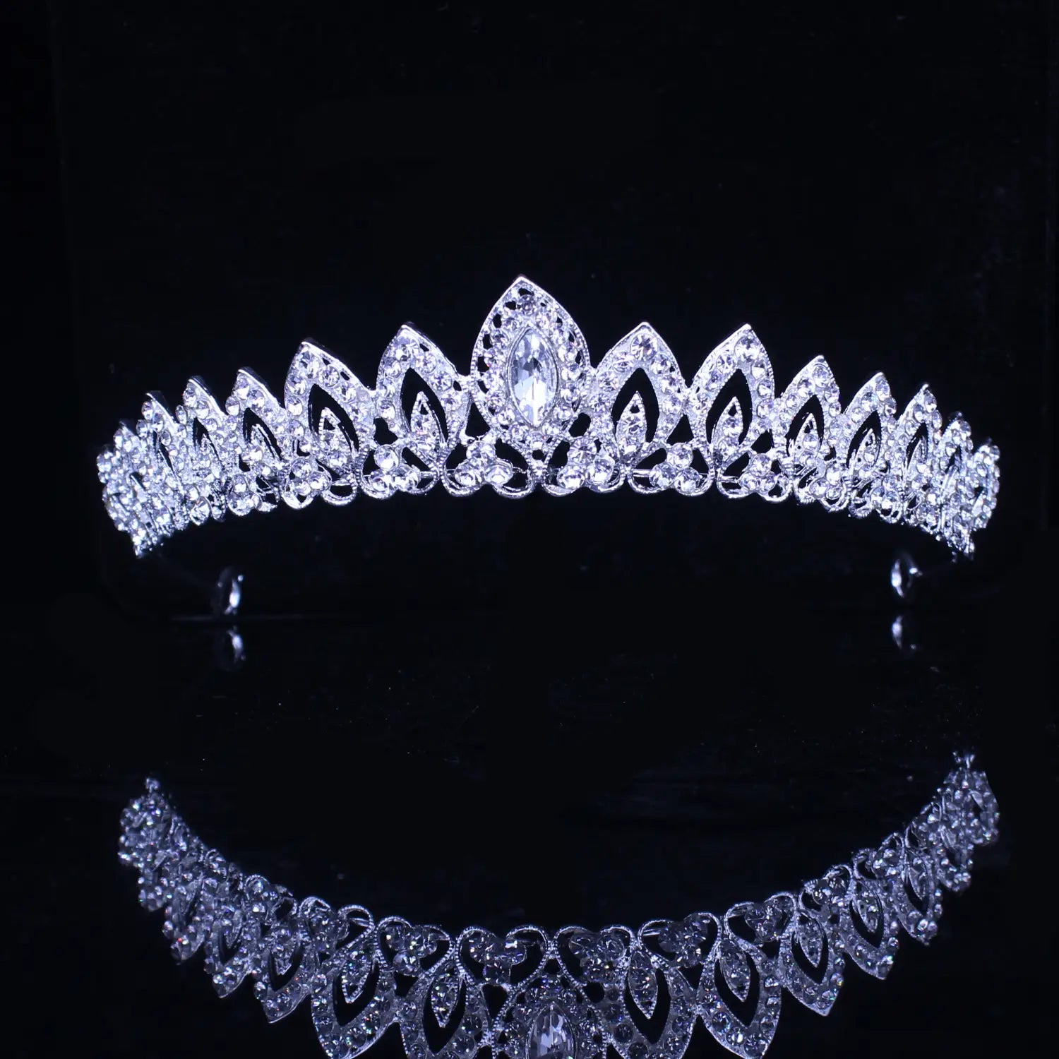 Diadema de boda floral con tiara de novia de cristal que presenta un diseño plateado brillante con intrincados patrones en forma de hojas y un cristal central en talla marquesa.