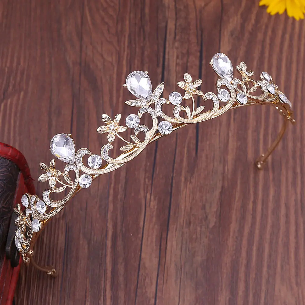 Tiara de novia de cristal color dorado con diseños florales y de enredaderas intrincados, adornada con cristales transparentes con forma de gota y redondos para su uso como diadema de boda.