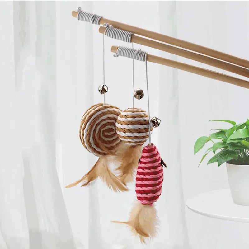 Conjunto de tres juguetes colgantes tipo caña para gatos con palo de madera, envueltos con cuerda en tonos naturales marrón, blanco y rojo, para el juego interactivo de gatos domésticos.