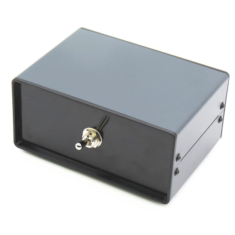 A black rectangular metal hifi audio switcher 2 way speaker selector box with a gold-colored toggle switch on the front.