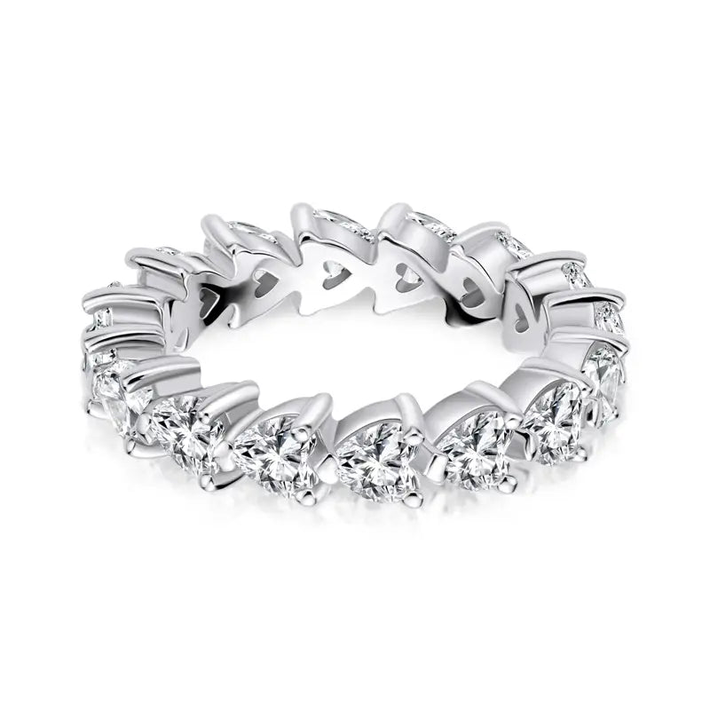 Une élégante bague d’éternité cœur en argent sterling, dotée d’une rangée continue de diamants taillés en rond étincelants, sertis dans un design de griffes en forme de cœur élégant.