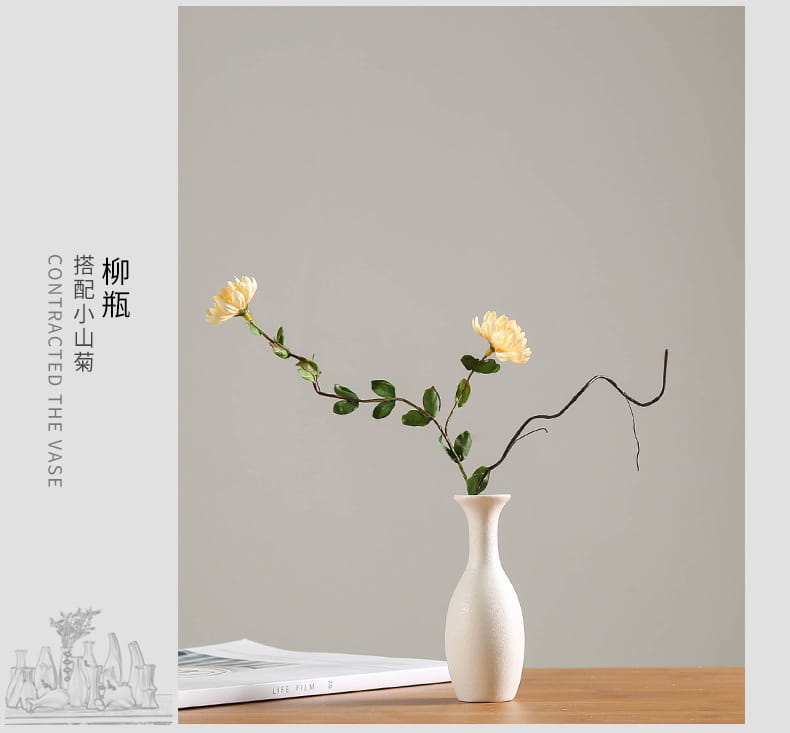 Modern white ceramic vase with a slender neck and rounded base elegantly holding two pale yellow flowers for floral decor.