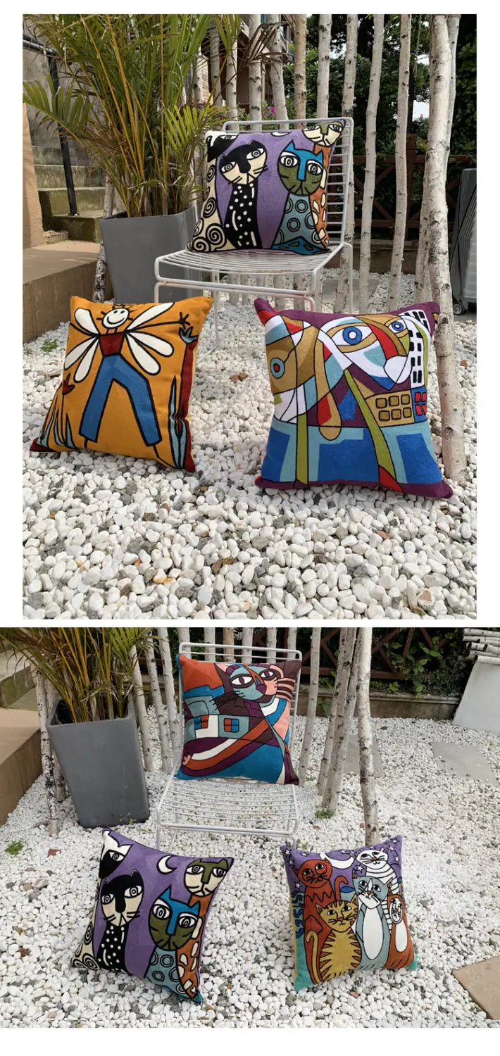 Housse de coussin brodée 45 x 45 cm présentant une œuvre abstraite colorée avec des motifs stylisés audacieux de personnages fantaisistes et de chats dans des tons orange, bleu, violet et turquoise vifs