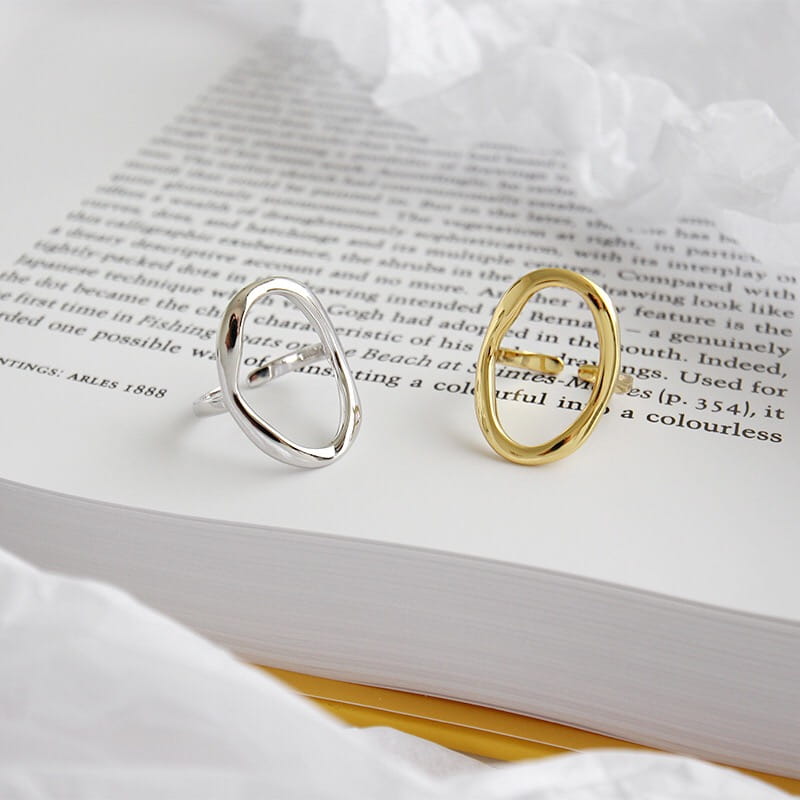 Two minimalist open oval sterling silver adjustable rings for women in silver and gold with a sleek metallic finish.