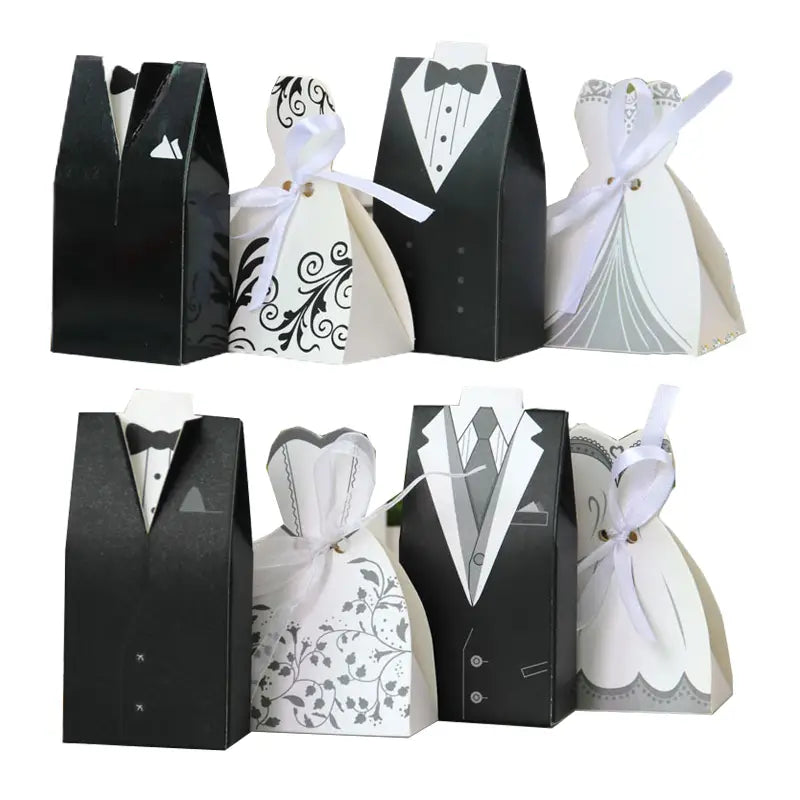 Elegant black and white paper bride and groom wedding favor candy boxes designed to resemble tuxedos and gowns with delicate ribbon ties in a set of 30 pieces.