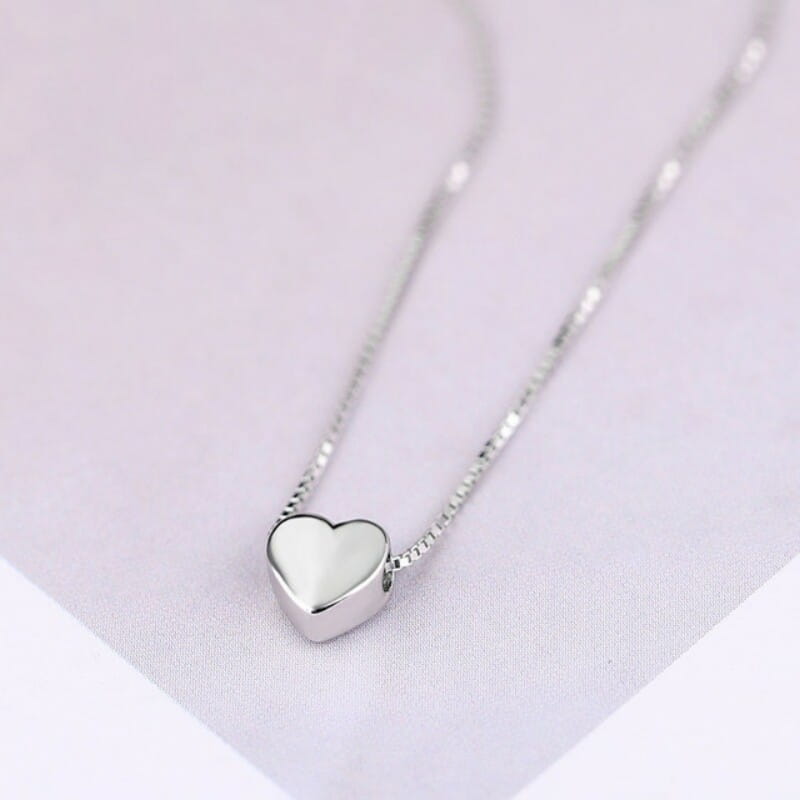 Collar minimalista de cadena tipo eslabones de papel en plata de ley, con un delicado colgante de corazón en plata, de acabado pulido y liso, y una fina cadena tipo caja.