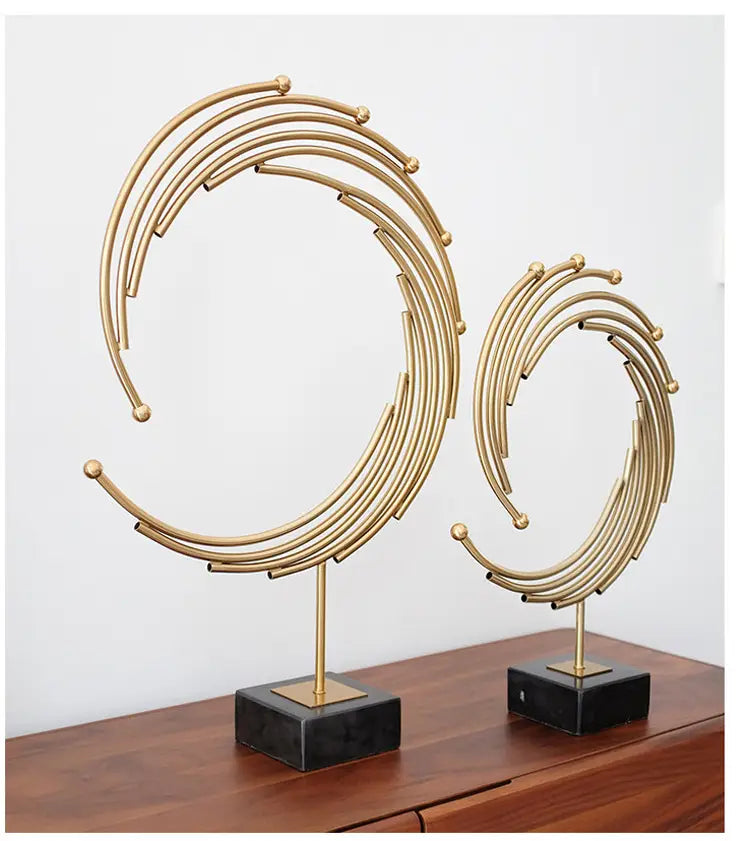 Gold metal abstract sculpture featuring gold-toned circular designs on black marble bases for office desk decor.