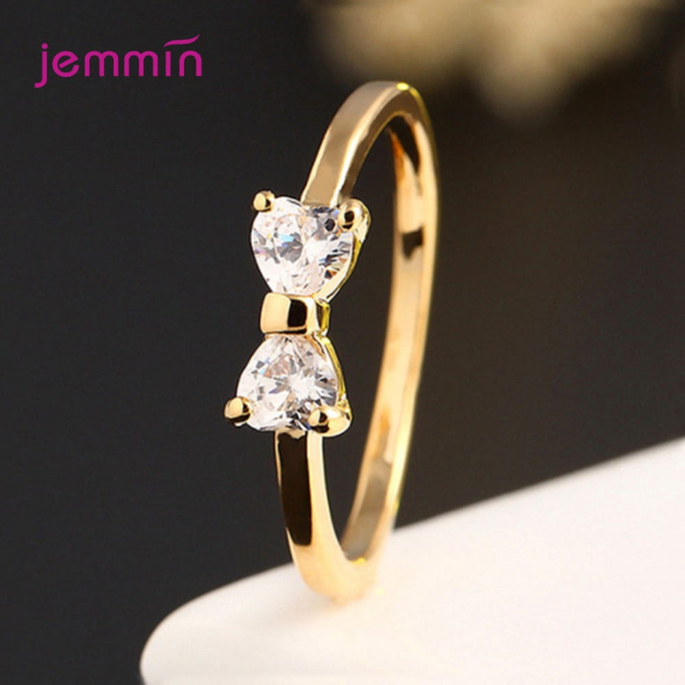 Bague de mariage en nœud en argent sterling en oxyde de zirconium cubique, de couleur or, présentant deux pierres claires taillées en forme de cœur dans un design délicat.