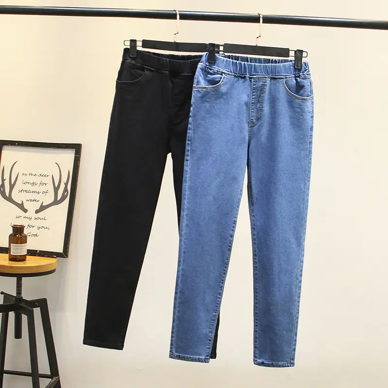 Une paire de jeans en denim bleu clair extensible taille haute de couleur bleu classique, avec un léger effet délavé et des détails de surpiqûres visibles.