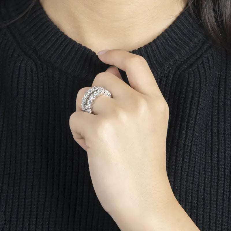 Une bague d’éternité cœur en argent sterling, dotée d’une bande de diamant étincelante avec un sertissage en métal à tonalité argentée.