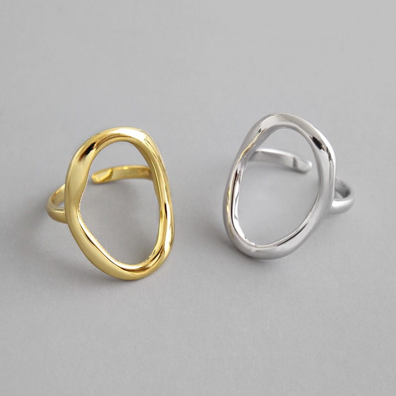 Two minimalist open oval rings in gold and silver made of polished sterling silver with an adjustable sleek modern design for women.