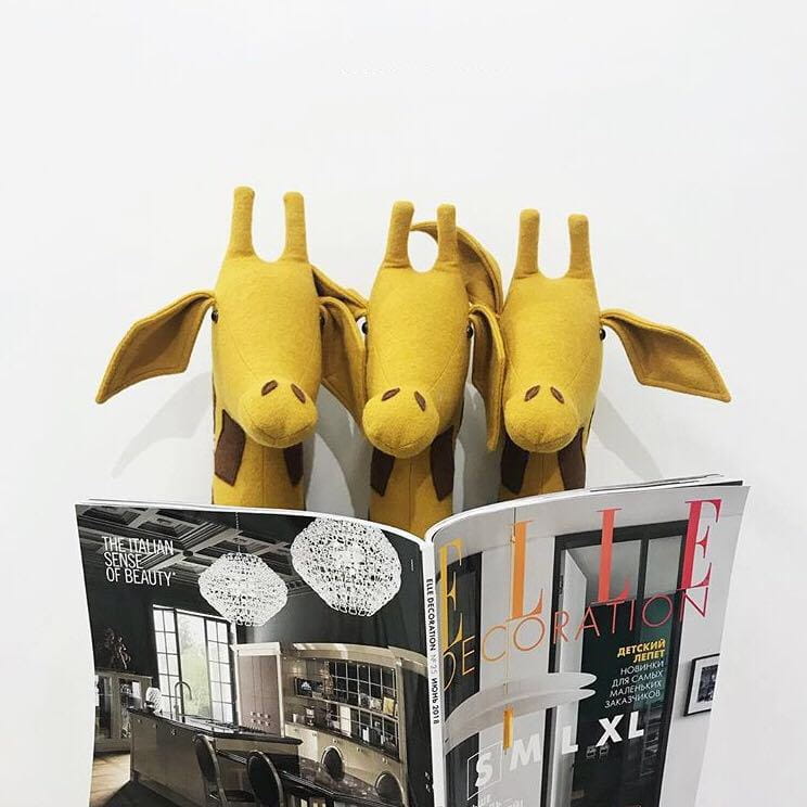 Drei gelbe Plüsch-Giraffen-Buchstützen mit braunen Flecken und weicher Stoffstruktur, entworfen als 3D-Cartoon-Tierkopf-Wanddekoration