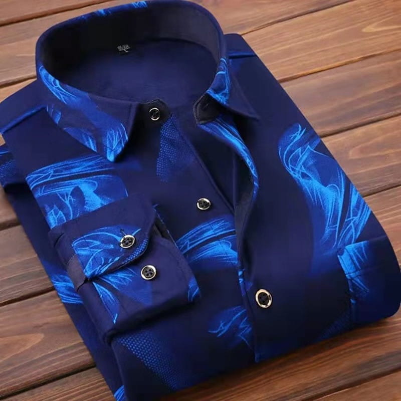 Chemise décontractée pour homme à coupe ajustée, manches longues, en bleu marine, avec un motif abstrait de feuilles éclatant dans des tons de bleu plus clairs, avec des accents noirs au niveau du col et des poignets.