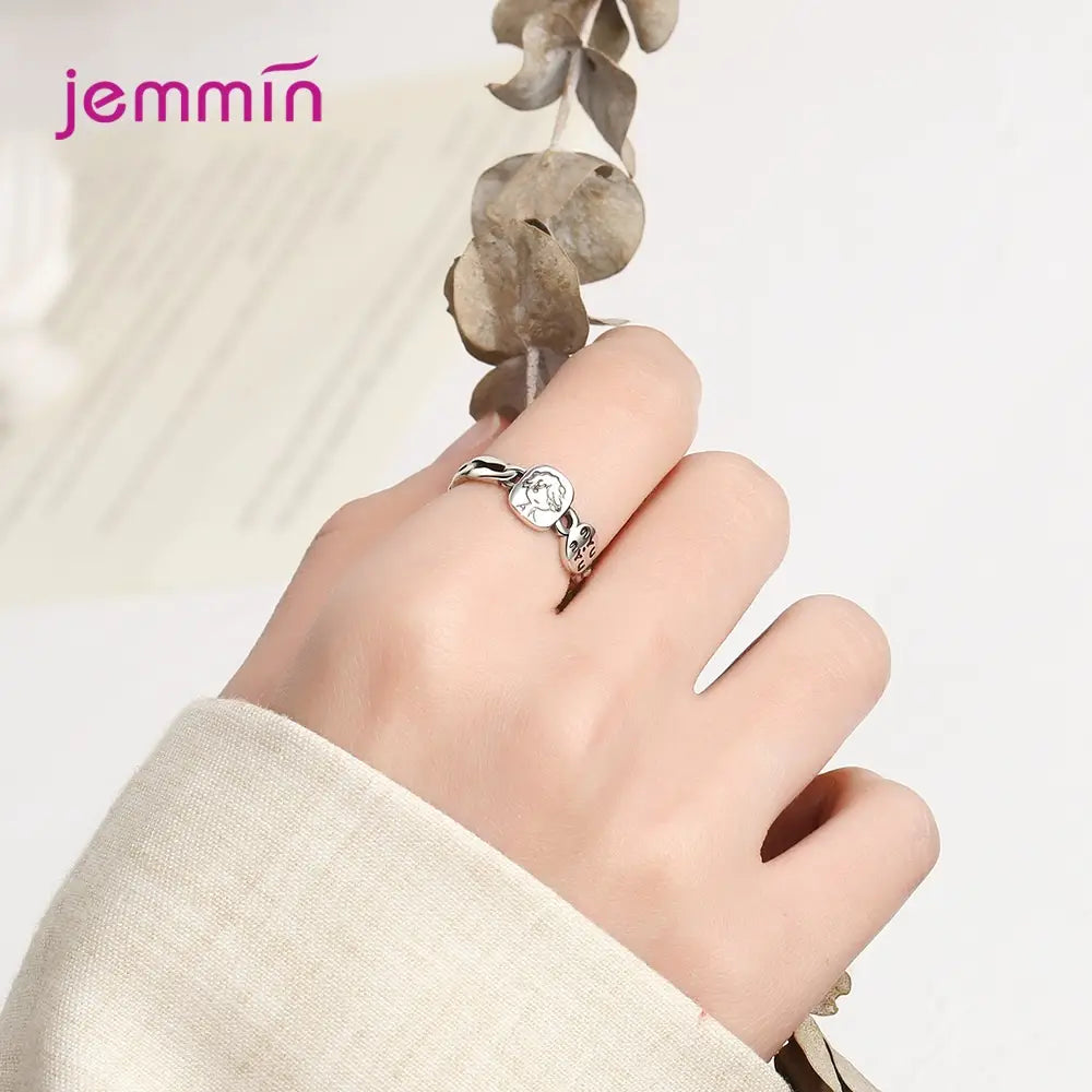 Bague réglable à motif facial en argent sterling Jemmin, en argent, avec un emblème central à thème floral et une délicate ornementation ajourée sur une monture élégante.