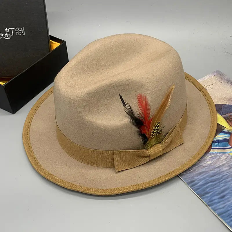 Beige woolen felt fedora hat with tan ribbon bow and decorative feather accent for unisex use.