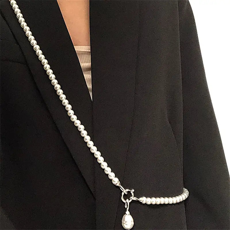 Collier en argent orné de perles, avec un pendentif en forme de goutte de perle et une fermeture à bascule en argent.