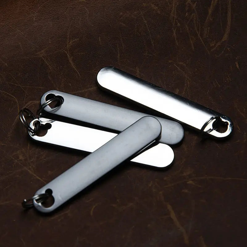Silver metallic custom phone number keychain tags with a sleek elongated rectangular design and polished finish laser engraved on metal key rings.