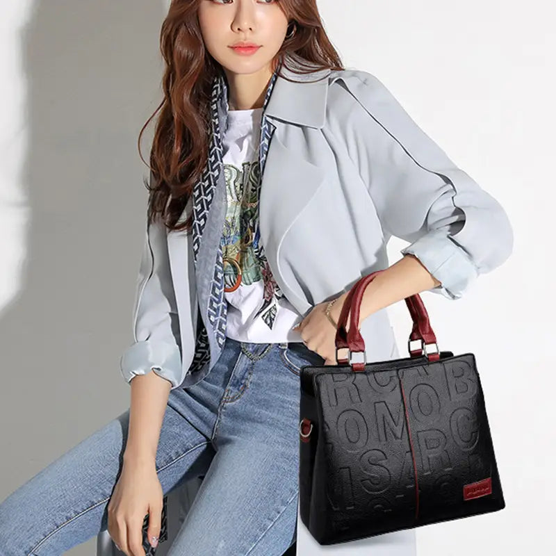 black crossbody handbag style1 style2 made of pu leather with embossed lettering and red leather handles satchel style