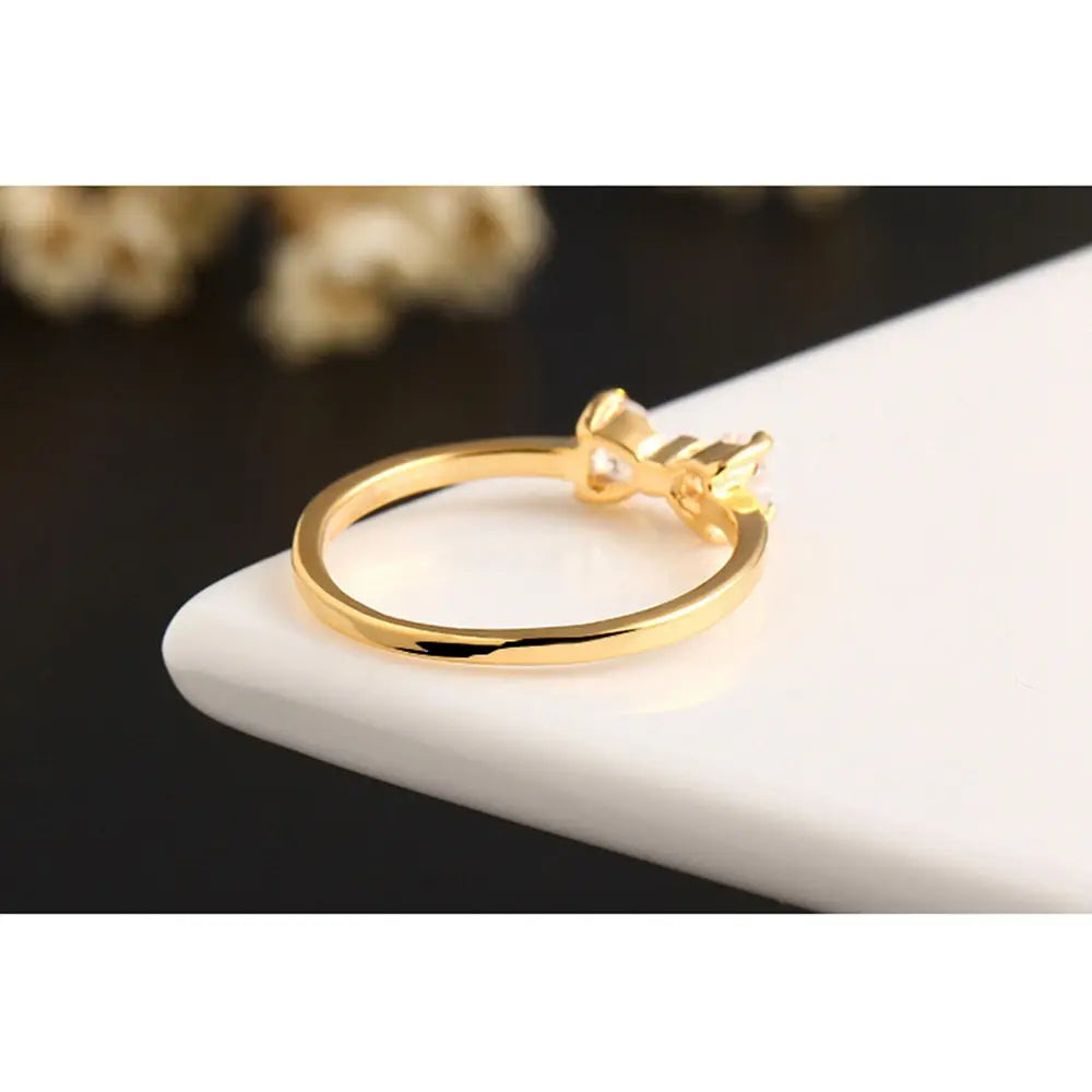 Bague de mariage en nœud en argent sterling, ton or, en oxyde de zirconium cubique, présentant un délicat élément central en forme de nœud avec une petite pierre claire au centre.