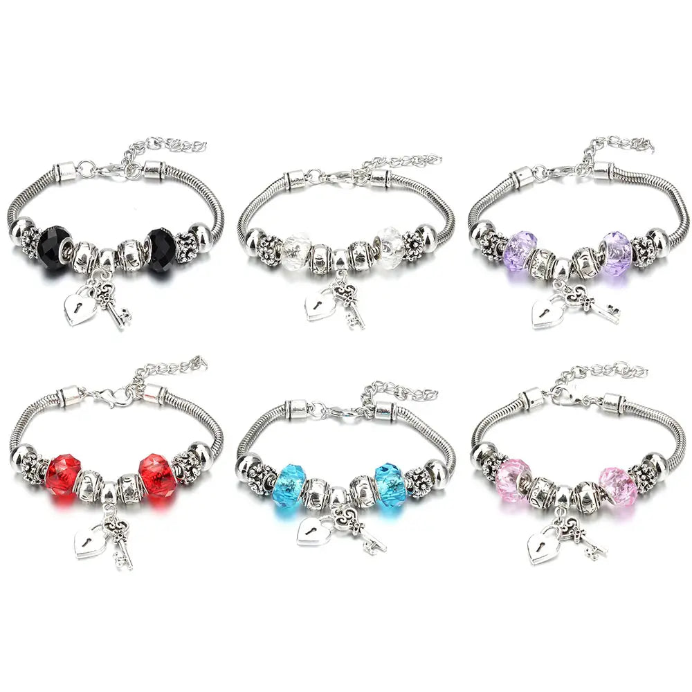 charm bracelet with crown and key charms for women featuring six silver-toned beaded bracelets with clear and colored crystal beads in black red blue purple and pink hues.